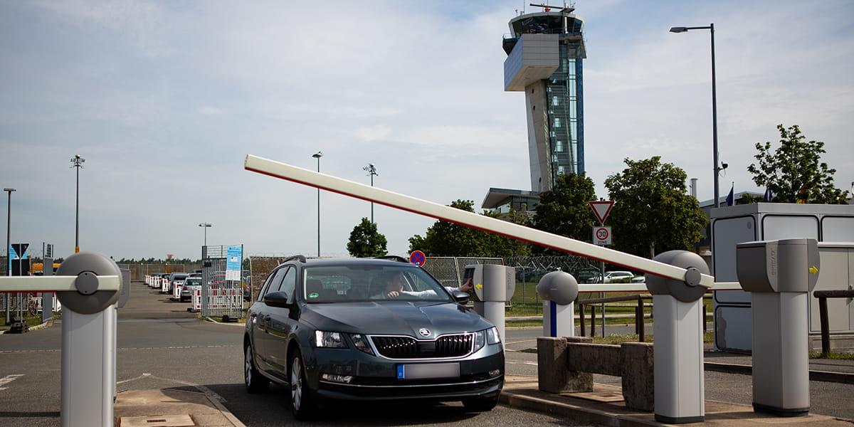 Car entering an airport parking facility through the entrance gate