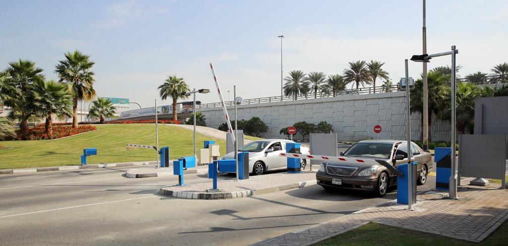 Cars entering an automated airport parking lot through barrier gates