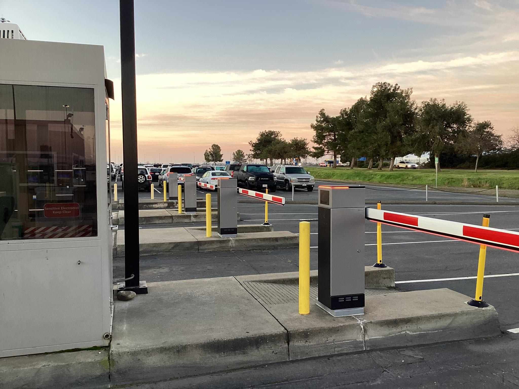 Cars entering and exiting an airport parking lot through barrier gates