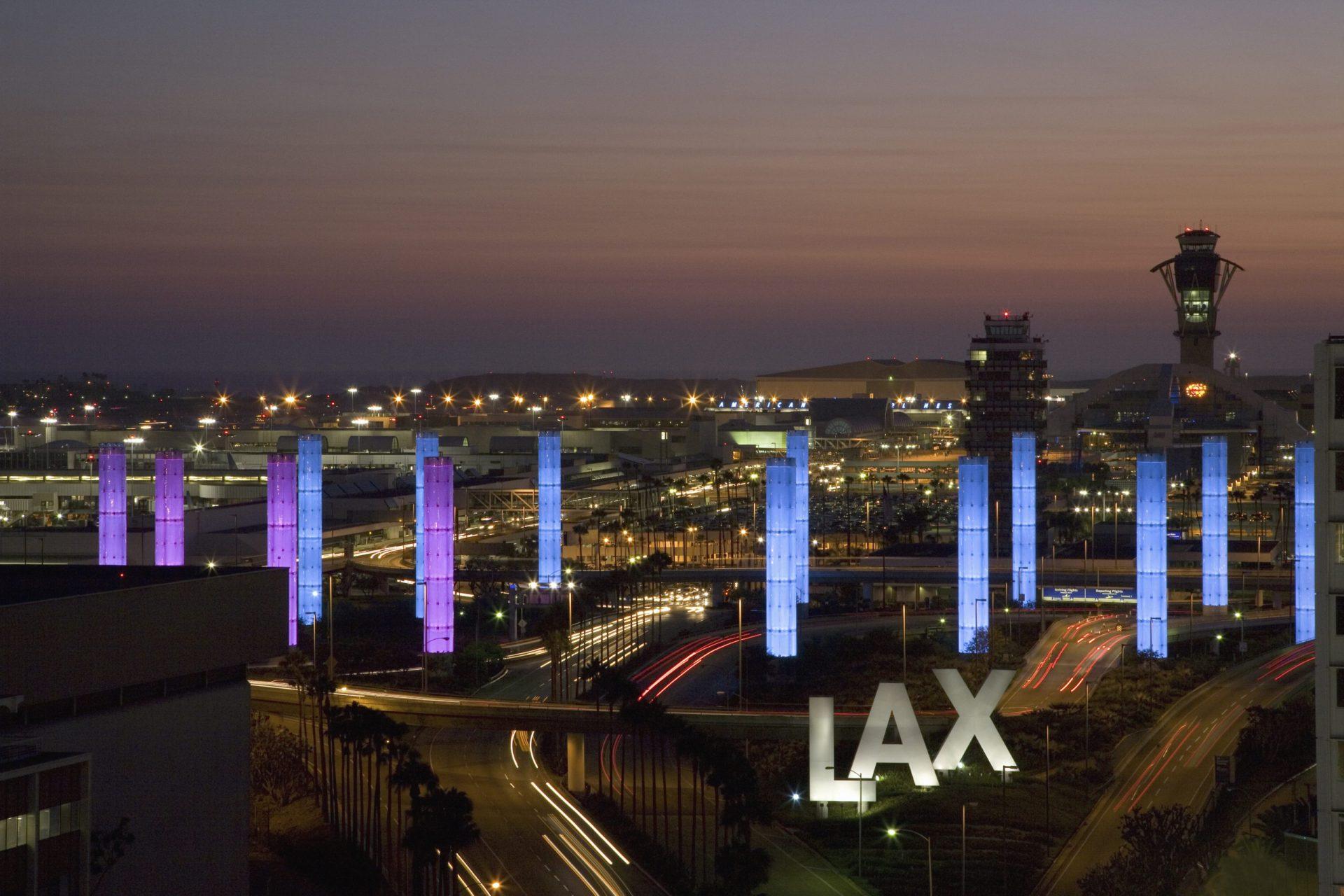 LAX Airport before sunrise with illuminated entrance and air traffic control tower